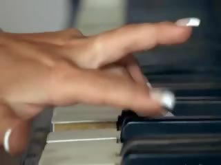 Грудаста блондин граючи кицька на в піаніно