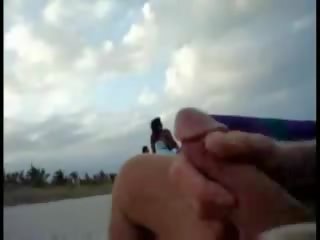 Américain touriste paluchage sur la plage tandis que femme passing par mov